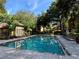 Inviting 6-foot deep community pool surrounded by mature trees, lounge chairs, and manicured landscaping at 6304 Raleigh St # 204, Orlando, FL 32835