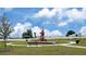 Community playground featuring play structure, benches, walking path and green space against a bright blue sky at 734 Ginger Dr, Haines City, FL 33844