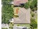 Aerial view of a tan house featuring a manicured lawn, shrubs, and healthy green trees at 7900 Saint Giles Pl, Orlando, FL 32835