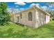 Green backyard with well-maintained lawn and bright beige single story house at 7900 Saint Giles Pl, Orlando, FL 32835