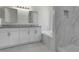 Bathroom with a double vanity, granite countertops, a soaking tub, and a tiled shower at 7900 Saint Giles Pl, Orlando, FL 32835