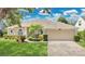 Charming single-story home with lush landscaping and a well-manicured lawn at 7900 Saint Giles Pl, Orlando, FL 32835