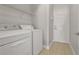 Laundry room with washer, dryer, white door, and tiled flooring at 7900 Saint Giles Pl, Orlando, FL 32835