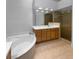 Primary bath with a soaking tub, walk-in shower, a dual-sink vanity and tile flooring at 84 Camino Real Blvd, Howey In The Hills, FL 34737