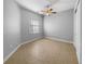 Bedroom with fan, tile floor, white walls, baseboard trim, and window at 84 Camino Real Blvd, Howey In The Hills, FL 34737