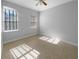 Bright, bare bedroom with tile flooring, a ceiling fan and two windows with natural light at 84 Camino Real Blvd, Howey In The Hills, FL 34737