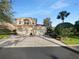 Two-story home with a two car garage and a brick paved driveway under a bright blue sky at 84 Camino Real Blvd, Howey In The Hills, FL 34737