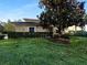 Charming, one story home with mature trees, green lawn, and clipped bushes at 84 Camino Real Blvd, Howey In The Hills, FL 34737
