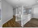 Upstairs hallway with white railing, wood floors, white walls, and natural light at 84 Camino Real Blvd, Howey In The Hills, FL 34737