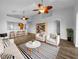 Bright living room with modern decor, ceiling fans, stylish furniture, and wood-look tile flooring at 84 Camino Real Blvd, Howey In The Hills, FL 34737