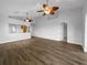 Spacious, bright living room with wood-look tile flooring and contemporary ceiling fans at 84 Camino Real Blvd, Howey In The Hills, FL 34737