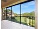 Screened patio with tile, black metal railing, golf course view, and palm trees at 84 Camino Real Blvd, Howey In The Hills, FL 34737