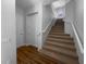 Carpeted staircase with white railing and wood flooring at the bottom at 84 Camino Real Blvd, Howey In The Hills, FL 34737