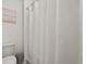 Clean bathroom showcases a white shower curtain, a toilet, and tasteful beach-themed artwork for a serene atmosphere at 850 Lazio Cir, Debary, FL 32713