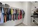 Walk-in closet with metal hanging racks full of clothes, carpet flooring, and white trim at 850 Lazio Cir, Debary, FL 32713