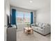 Cozy living room features a comfortable gray sofa, neutral carpet, and large window dressed with stylish blue curtains at 850 Lazio Cir, Debary, FL 32713