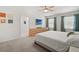 A primary bedroom features carpet flooring, white walls, ceiling fan, a TV and two windows with curtains at 850 Lazio Cir, Debary, FL 32713