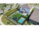 Aerial view of backyard with artificial turf, pool, outdoor seating, playground and black fencing at 9027 Coral Cape St, Kissimmee, FL 34747