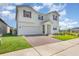 Angle view of a beautiful two-story home highlighting the brick driveway, attached two-car garage, and manicured lawn at 9027 Coral Cape St, Kissimmee, FL 34747