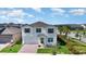 Elevated angle of a two-story home with a brick driveway, lush landscaping, and a view of the neighborhood beyond at 9027 Coral Cape St, Kissimmee, FL 34747