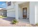 Welcoming front entrance featuring a beautiful wood door, brick-paved driveway, and well-maintained landscaping at 9027 Coral Cape St, Kissimmee, FL 34747