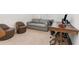 Inviting living room featuring a comfortable sofa, modern chairs, a wooden desk, and neutral carpeting at 9027 Coral Cape St, Kissimmee, FL 34747