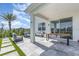 Covered patio featuring a modern seating area, tropical landscaping, and a dining table at 9027 Coral Cape St, Kissimmee, FL 34747