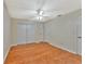 Clean, well-lit bedroom with wood laminate flooring, ceiling fan, and ample closet space at 935 Northern Dancer Way # 107, Casselberry, FL 32707