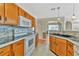 Cozy kitchen features tile backsplash, white appliances, wood cabinets and modern sink at 935 Northern Dancer Way # 107, Casselberry, FL 32707
