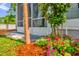 Landscaping near the screened in porch shows lush pink and white flowers with a tropical tree at 935 Northern Dancer Way # 107, Casselberry, FL 32707