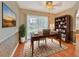 Well-lit home office featuring a wooden desk, bookcase, and a sliding door to the outside at 935 Northern Dancer Way # 107, Casselberry, FL 32707
