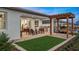 Spacious backyard featuring a covered patio, outdoor kitchen, pergola swing, and lush artificial turf at 944 Club Cresswind Dr, Lady Lake, FL 32159