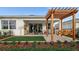 Landscaped backyard with patio, outdoor kitchen, pergola swing, and artificial turf at 944 Club Cresswind Dr, Lady Lake, FL 32159
