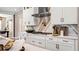 Chef's kitchen features white cabinets, quartz countertops, marble backsplash, and stainless steel appliances at 944 Club Cresswind Dr, Lady Lake, FL 32159