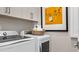 Laundry room featuring modern appliances, storage cabinets and a decorative art print at 944 Club Cresswind Dr, Lady Lake, FL 32159