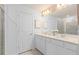 This bathroom features a double sink vanity with a large mirror and a glass door shower at 10148 Hadley St, Orlando, FL 32829