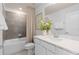 Bright bathroom featuring a shower over the tub, a modern vanity, and a decorative flower arrangement at 10148 Hadley St, Orlando, FL 32829