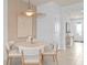 Bright dining area with a modern light fixture, neutral-toned furniture, and a view of the entryway at 10148 Hadley St, Orlando, FL 32829