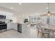 Open-concept kitchen and living area featuring stainless steel appliances, white cabinets, and neutral decor at 10148 Hadley St, Orlando, FL 32829