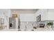 Well-equipped kitchen featuring white cabinets, stainless steel appliances, and an adjacent dining area at 10148 Hadley St, Orlando, FL 32829