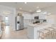 Well-lit kitchen with white cabinets, stainless steel appliances, and a center island with bar stool seating at 10148 Hadley St, Orlando, FL 32829
