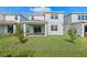 Well-maintained backyard with green grass, landscaping, and a covered patio with sliding door at 10245 Park Estates Ave, Orlando, FL 32836