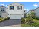 Two-story home featuring a two car garage, a teal entry door and brick paved driveway at 10245 Park Estates Ave, Orlando, FL 32836