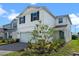 Two-story home with a two car garage, a teal entry door and professionally landscaped yard at 10245 Park Estates Ave, Orlando, FL 32836