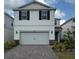 Two-story home with a two-car garage, brick driveway, and manicured landscaping at 10245 Park Estates Ave, Orlando, FL 32836