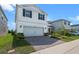 Two-story home showcasing landscaped yard and a brick paved driveway at 10245 Park Estates Ave, Orlando, FL 32836