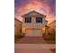 Charming two-story home with a two-car garage, brick driveway, and beautiful sunset sky at 10245 Park Estates Ave, Orlando, FL 32836