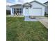 Well-manicured front lawn leading to a charming home with a white exterior and bright blue window shutters at 1025 Clovercrest Rd, Orlando, FL 32811