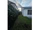 Side yard featuring a faux plant privacy fence and grass area at 1025 Clovercrest Rd, Orlando, FL 32811