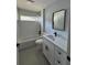 Bathroom featuring white tiling, black fixtures, white vanity, and a tub shower at 10641 Sw 110Th Ct, Dunnellon, FL 34432